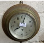 Brass Framed Porthole shaped Wall Clock, with silvered dial, with circular mahogany back, stamped “