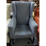 Edwardian Highback Armchair, with blue velvet fabric, on high turned legs, castors