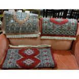 Similar pair of small sized wool floor rugs, red ground with diamond medallions (48” x 30”, 35” x