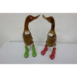 2 carved wooden ducks, wearing colourful (gold, black) porcelain boots 19”h