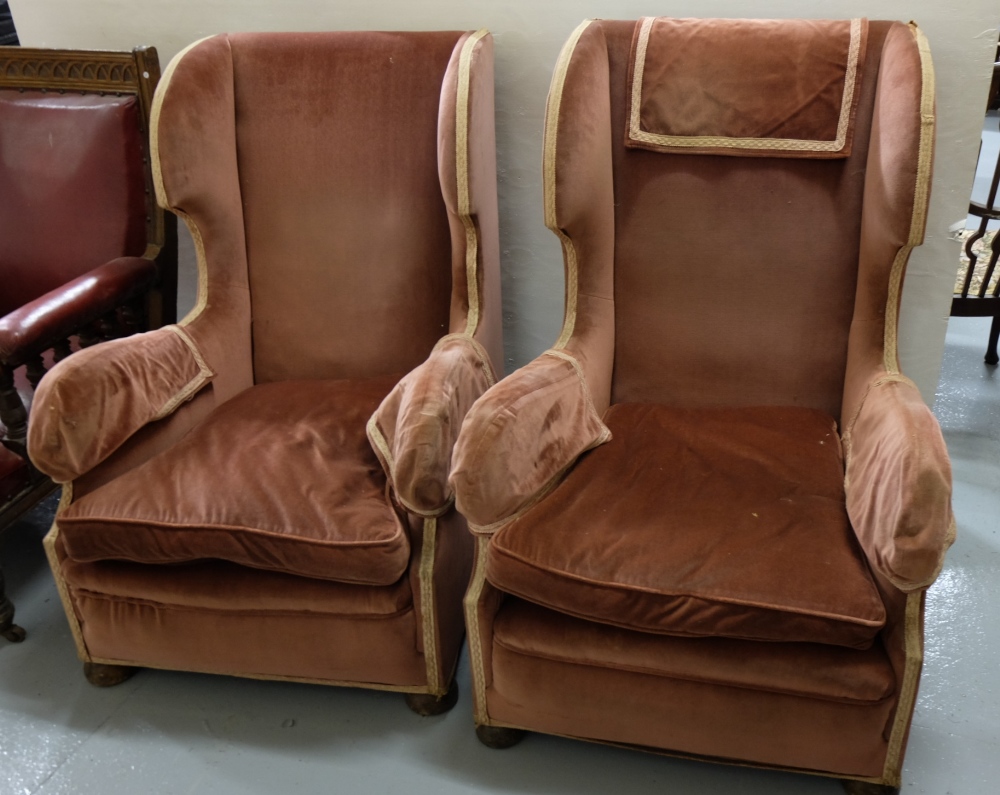 Matching Pair of High Wingback Armchairs, covered with pink velour fabric, button feet