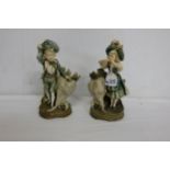 Pair of Austrian “Turn Wein” Porcelain Figures – a Boy and Girl in green costumes, beside shell