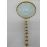 Large magnifying glass, in a brass and mother of pearl inlaid frame, 16”h