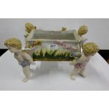 Porcelain Basket Centrepiece, supported by 4 cherubs, overlaid with flowers, 14”w x 9”d x 9”h