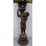 Bronze Urn, supported by a classic Boy, on a raised plinth, 16”w x 50”h