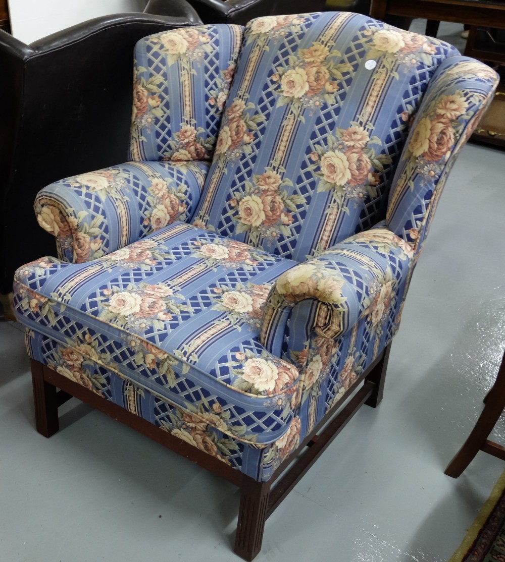 Wingback Armchair, covered with a blue and pink floral fabric, on a mahogany frame with reeded