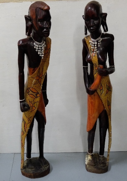 Pair of African carved Figures of Man & Woman in traditional costume, each 4ft high