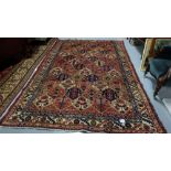 Predominantly red ground Persian Hamadan carpet with an all over garden design 3.05mx2.05m