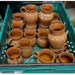 Large group of terracotta mugs, with painted designs (in box)