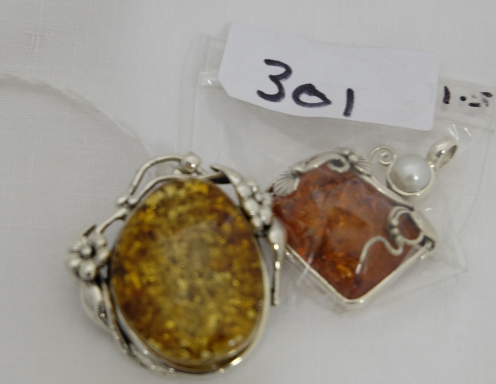 2 silver mounted Pendants with amber pastes (1 with a pearl) (2)