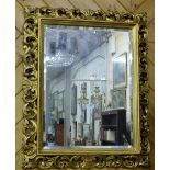 Gilt Framed Wall Mirror with raised foliate borders, bevelled glass, 32”h x 27”w