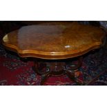 Victorian walnut centre table with a serpentine shaped top, over 4 scrolled supports and 4
