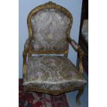 Pair of Carved Gilt Wood Armchairs, with decorative finials, gold ground fabric on a padded seat and