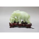 Chinese carved green jade elephant, approx 19cm H x 25cm including stand