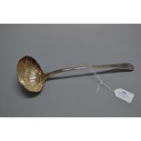 A mid 18th century Rococo sterling silver soup ladle, with a fluted bowl and a crest to terminal