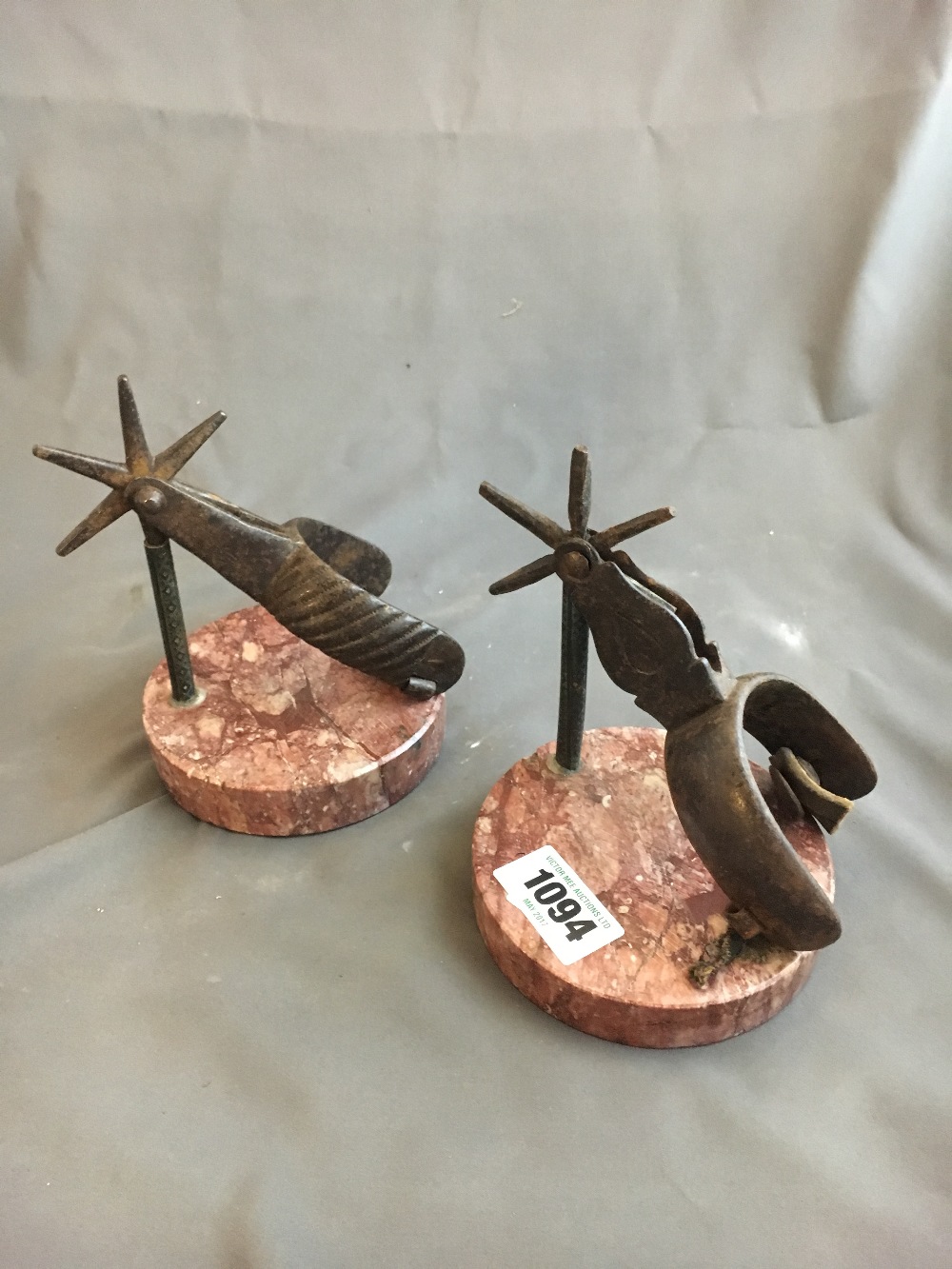 Two stirrups mounted on marble bases.