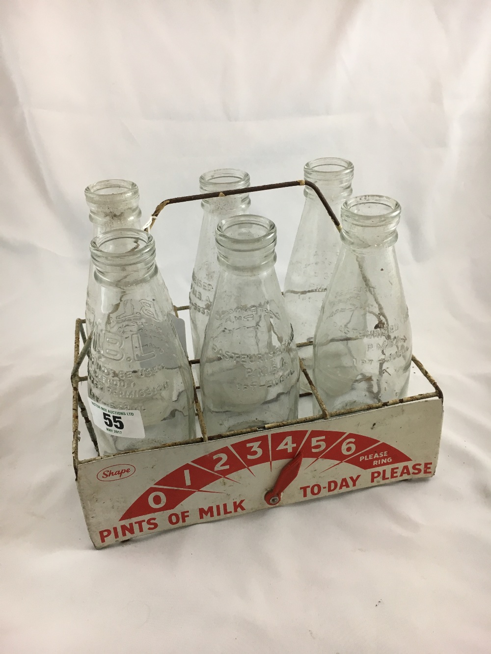 Milk bottle carrier and six old milk bottles.