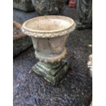 Composition garden urn on pedestal.