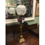 Victorian Corinthian columned oil lamp with cranberry bowl and etched football shade.