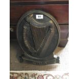 Cast iron plaque decorated with a harp.