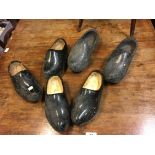 Three pairs of wooden clogs.