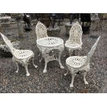 Set of four cast iron garden chairs and a circular table.
