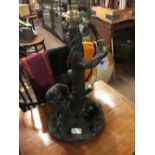 Packed bronze table lamp in the form of a tree trunk and two men.