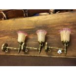 Three old converted brass gas light wall fittings with glass shades.