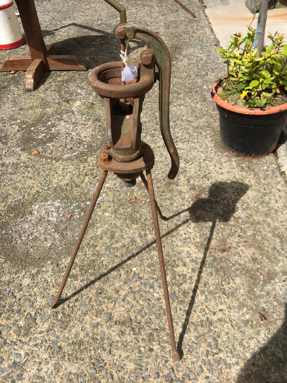 Cast iron water pump on stand.