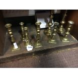 Three pairs of brass candlesticks and one other.