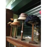 Four vintage ladies hats and stands.