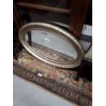 Gilded oval wall mirror.