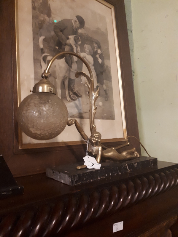 Brass reclining lady in the form of a lamp mounted on a marble base in the Art Deco style.