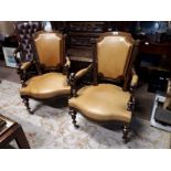 Pair of rosewood leather upholstered open armchairs with brass inlay.