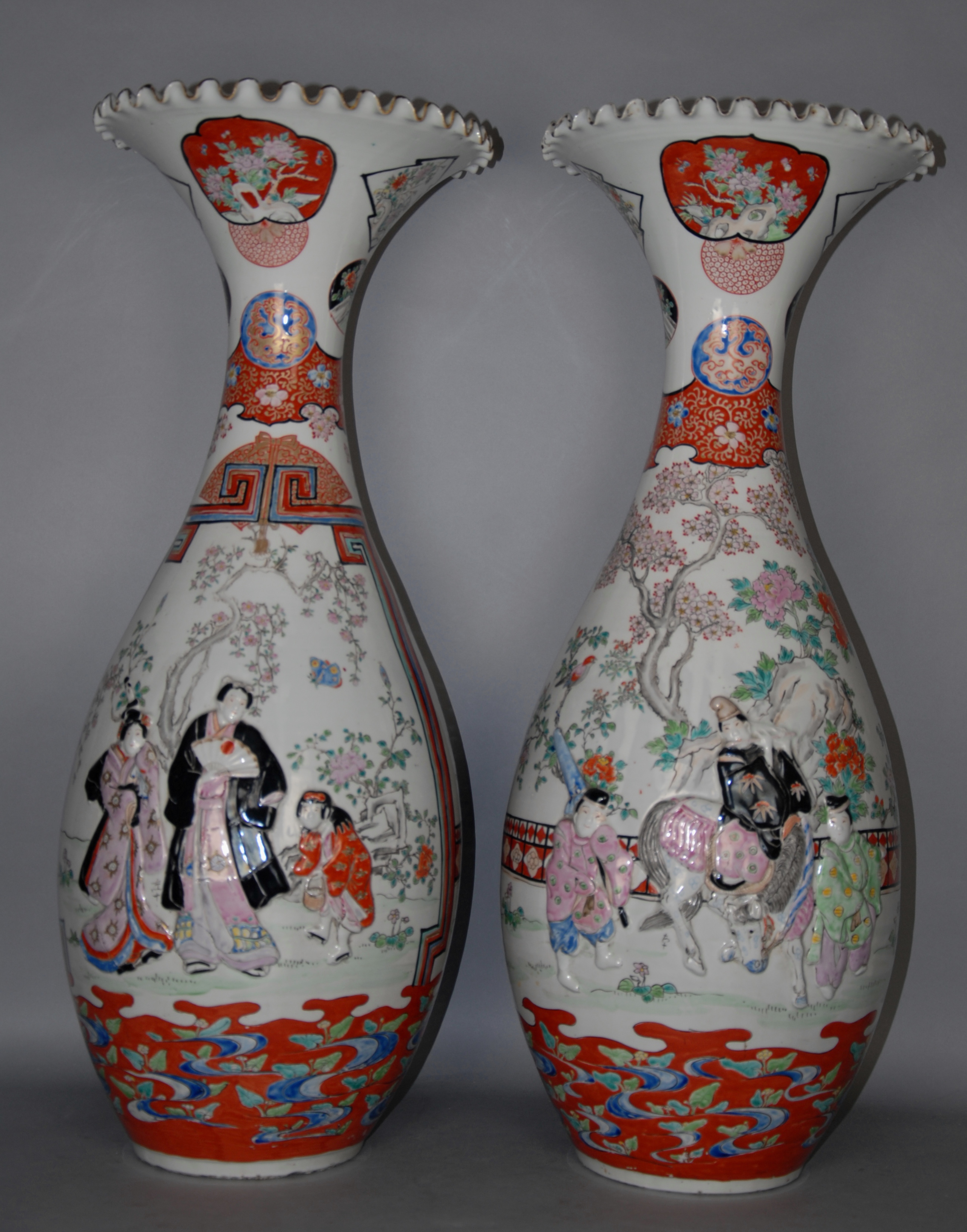 Due vasi in porcellana bianca con decoro floreale e figure a rilievo. Giappone. XX secolo. Lievi