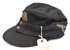 A Third Reich style black ski cap, with wool embroidered death’s head badge, SS eagle on left