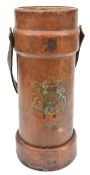 A brown leather shell bucket, with post 1902 R Arms, supporters and motto, carrying handle on