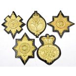 A set of 5 Brigade of Guards valise badges, each mounted on black leather, some with stamps for