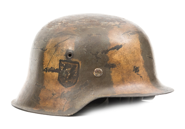 A Third Reich M42 steel helmet, the skull with added camouflage paint scheme and mostly