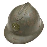 A WWII French Adrian steel helmet, dark olive green with replacement artillery badge, the inside