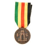A Third Reich Afrika Corps medal, and a bronzed wreath badge marked “1933”. GC