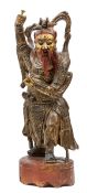 A Japanese carved wooden figure of a sage, with panels of applied plaster decoration and hair