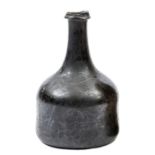 An early 18th century mallet shape wine bottle, of dark green glass, deep punt to base, 6½” overall,