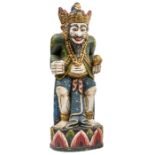 A gilt and colour painted kris stand, in the form of a crouching bearded godlike figure, provision
