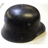 A German M16 steel helmet, black finish with white Landwehr cross painted on the back, with original
