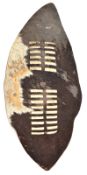 An ovoid dark/white hide shield, slotted central bands, 33” x 17”. GC