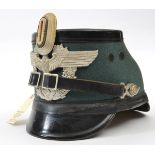 A Third Reich police shako, field grey body, black patent finish top and peaks, alloy mounts. Marked