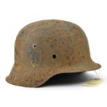 An excavated Third Reich M42 steel helmet, with remains of SS and party decals, heavily corroded