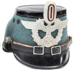 A good Third Reich police shako, field grey body, black patent top and peaks, alloy mounts, marked