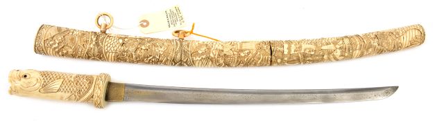 A composite Japanese carved bone sword wakizashi, blade 40cms, mumei, carved overall as a koi (
